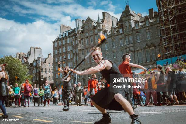 fire spinners perform in an edinburgh street parade - theasis stock pictures, royalty-free photos & images