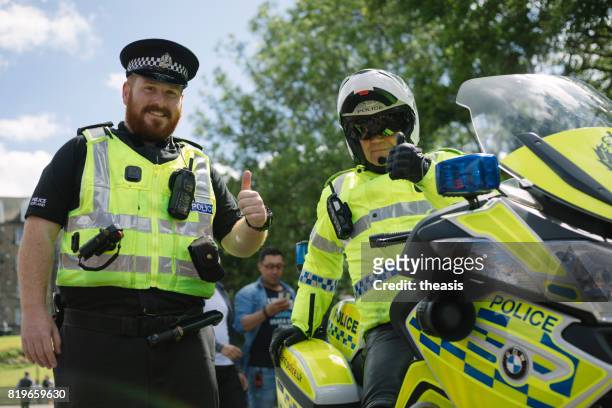 policía sonriente en un desfile de edimburgo - theasis fotografías e imágenes de stock