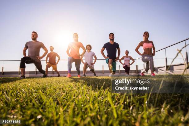 por debajo de la vista de los jóvenes atléticos con un entrenamiento en una terraza de los deportes. - exercise class fotografías e imágenes de stock