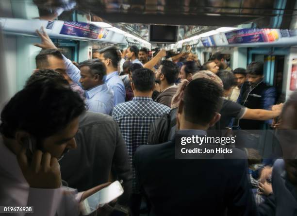 a crowded carriage during rush hour on the dubai metro. - dubai metro stock pictures, royalty-free photos & images