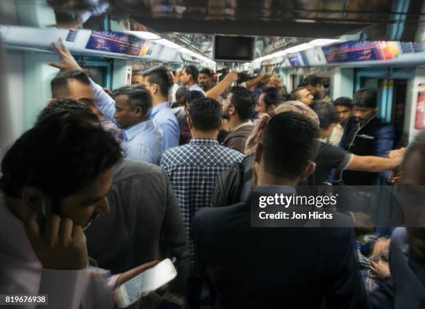 a crowded carriage during rush hour on the dubai metro. - comboio de metropolitano imagens e fotografias de stock