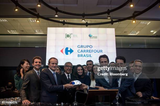 Billionaire Abilio Diniz, fourth left, and Charles Desmartis, chief executive officer of Grupo Carrefour Brasil, third left, ring the opening bell...