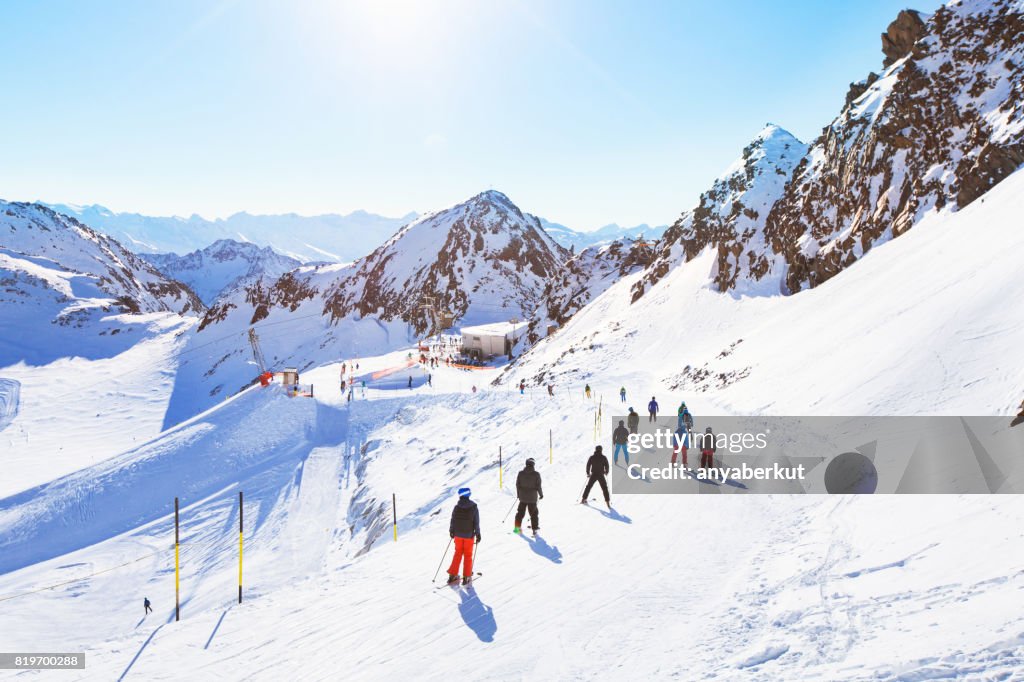 Unrecognizable skiers on beautiful ski slope in Alps