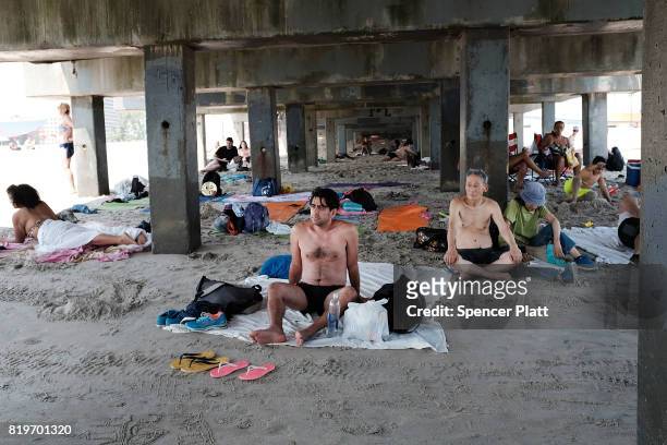 People enjoy a summer day at the beach at Coney Island on July 20, 2017 in the Brooklyn borough of New York City. Throughout the region people...