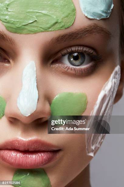 close up studio portrait of a beaiutiful woman with different facial masks on her face - exfoliation face stock pictures, royalty-free photos & images