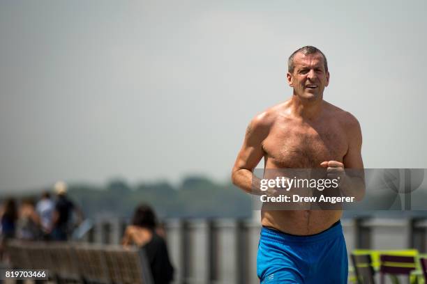 Man runs shirtless along Brooklyn Bridge Park, July 20, 2017 in the Brooklyn borough of New York City. Thursday is forecasted to be the hottest day...