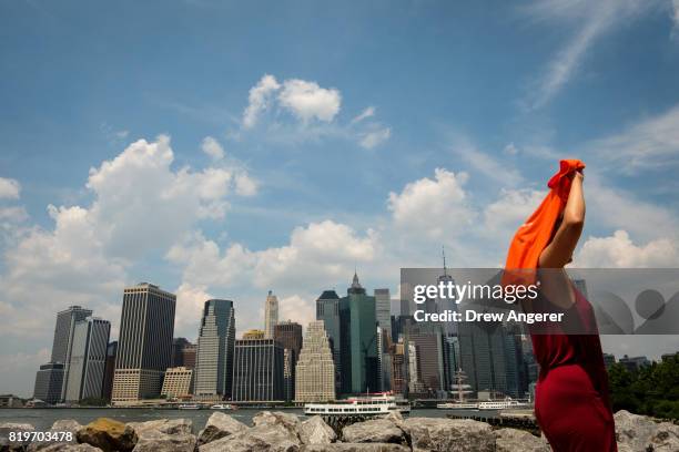 Woman shields herself from the sun in Brooklyn Bridge Park, July 20, 2017 in the Brooklyn borough of New York City. Thursday is forecasted to be the...