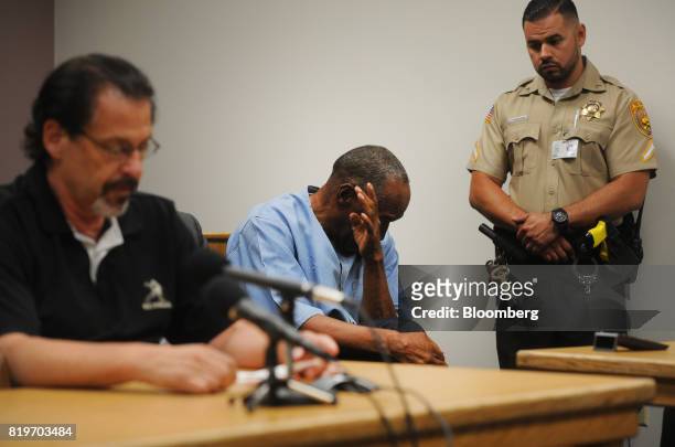 Former professional football player O.J. Simpson, center, reacts during the testimony of Bruce Fromong during a parole hearing at Lovelock...