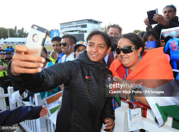 India Women's Harmanpreet Kaur takes a picture with a fan after victory in the ICC Women's World Cup Semi Final match at The County Ground, Derby.