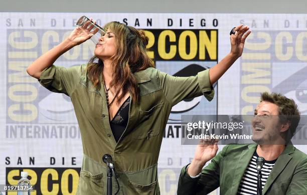 Actor Halle Berry takes a drink onstage while actor Pedro Pascal looks on at the 20th Century FOX panel during Comic-Con International 2017 at San...