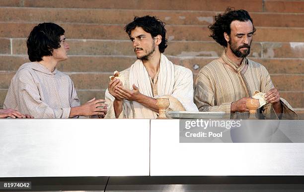 An actor playing Jesus, passes bread at the last supper during the The Stations of the Cross outside St Mary's Cathedral in Sydney, Friday, July 18,...