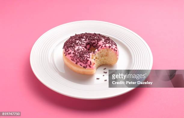 can't resist temptation bite out of doughnut - gekleurde hagelslag stockfoto's en -beelden