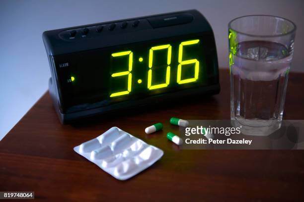 sleeping pills in bedroom - alarm clock on nightstand stock pictures, royalty-free photos & images