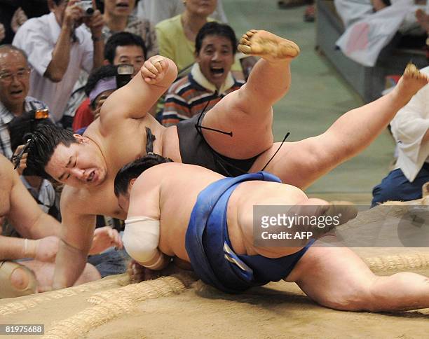 This picture taken on July 17, 2008 shows Mongolian sumo grand champion Asashoryu being pushed out of the ring by Tochinonada during the fifth day...