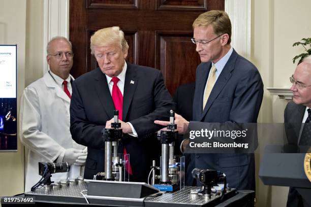 President Donald Trump, center, participates in a glass strength test of a conventional pharmaceutical vial with Wendell Weeks, chairman and chief...