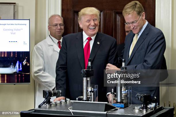 President Donald Trump, left, smiles after participating in a glass strength test of a conventional pharmaceutical vial with Wendell Weeks, chairman...