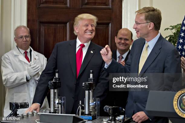 President Donald Trump, center, smiles after participating in a glass strength test of a Corning Valor vial with Wendell Weeks, chairman and chief...