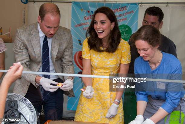 Prince William, Duke of Cambridge and Catherine, Duchess of Cambridge make sweets as they tour of a traditional German market in the Central Square...