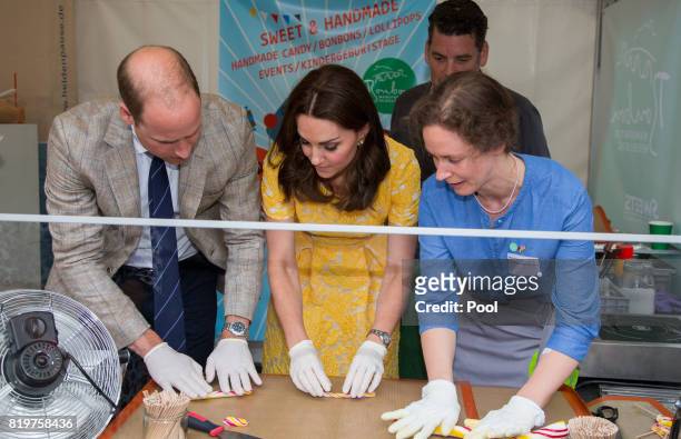Prince William, Duke of Cambridge and Catherine, Duchess of Cambridge make sweets as they tour of a traditional German market in the Central Square...