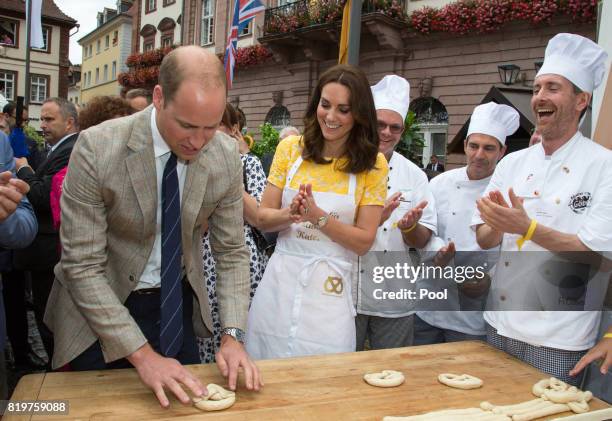 Prince William, Duke of Cambridge and Catherine, Duchess of Cambridge make pretzels as they tour a traditional German market in the Central Square...