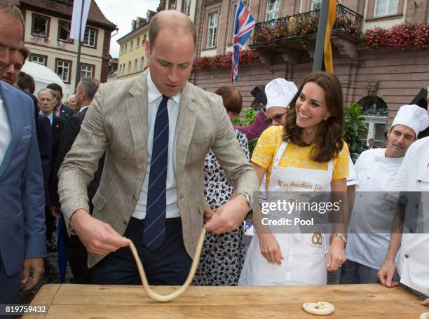 Prince William, Duke of Cambridge and Catherine, Duchess of Cambridge make pretzels as they tour a traditional German market in the Central Square...