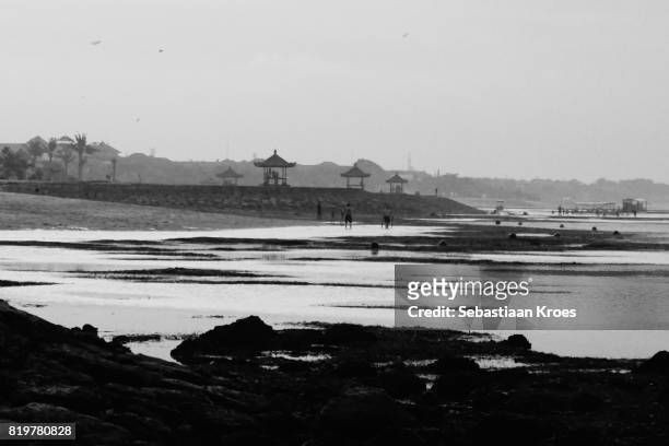 nusa dua coastline in black and white, dusk, kites, boat and people, bali, indonesia - indonesian kite stock pictures, royalty-free photos & images