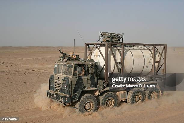British Army trucks from the 13 Air Assault Support Regiment drive through the desert during an operation to deliver supplies to several British Army...