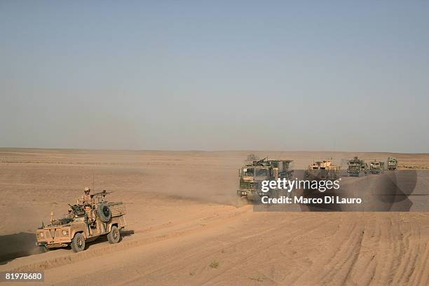 British Army trucks from the 13 Air Assault Support Regiment drive through the desert during an operation to deliver supplies to several British Army...