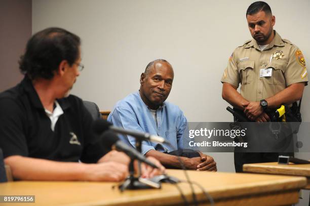 Former professional football player O.J. Simpson, center, smiles as Bruce Fromong testifies during a parole hearing at Lovelock Correctional Center...