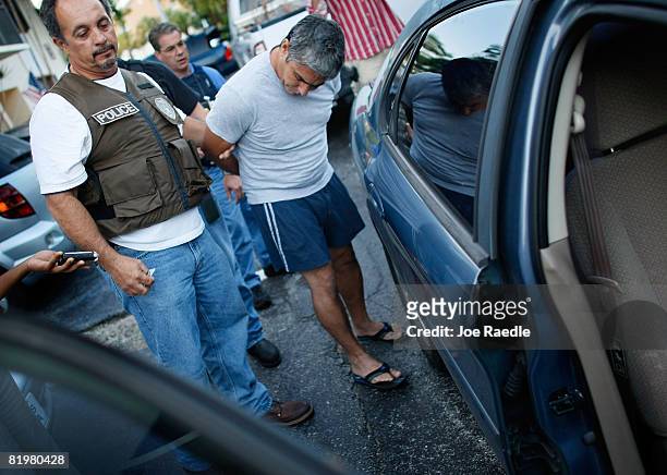 Member of the Miami-Dade police Mortgage Fraud Task Force takes Fernando Boix-Lopez into custody during an early morning raid July 17, 2008 in Miami,...