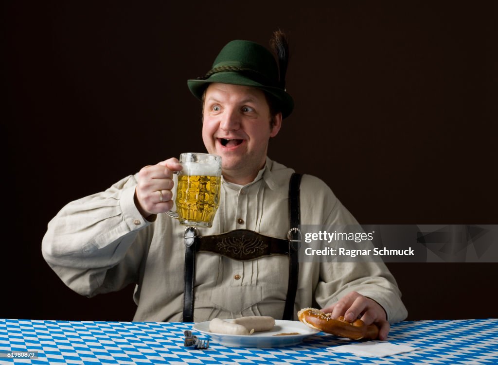 Stereotypical German man holding a beer and a pretzel