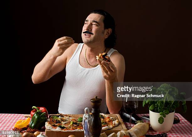 stereotypical italian man eating pizza and gesturing with hand - estereotipo fotografías e imágenes de stock