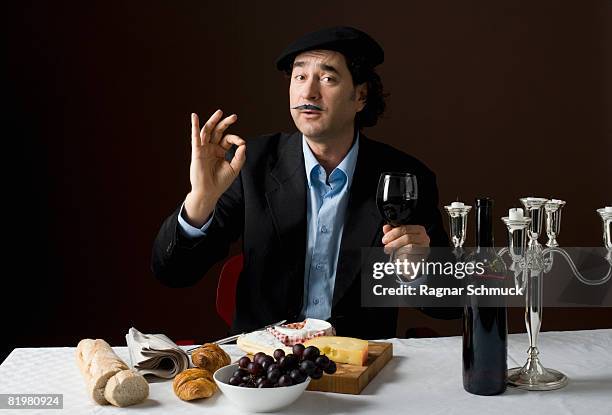 stereotypical french man with stereotypical french food - french cheese stockfoto's en -beelden