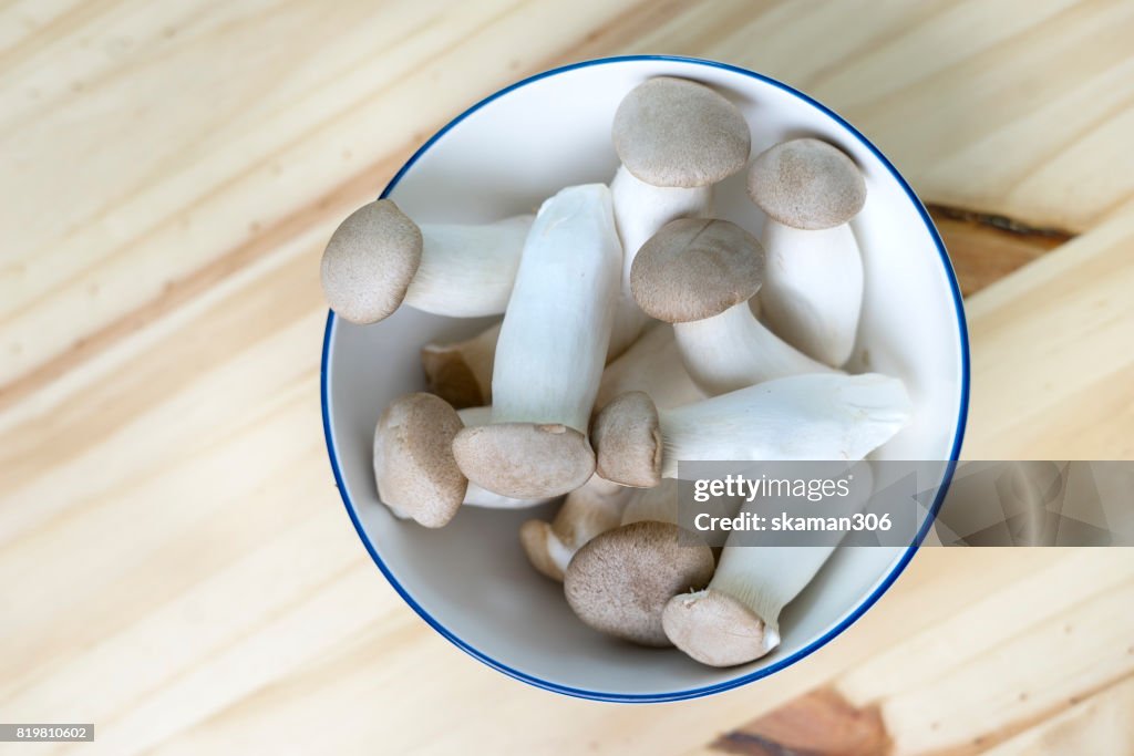 Clear light organic Japanese mushroom on wooden table