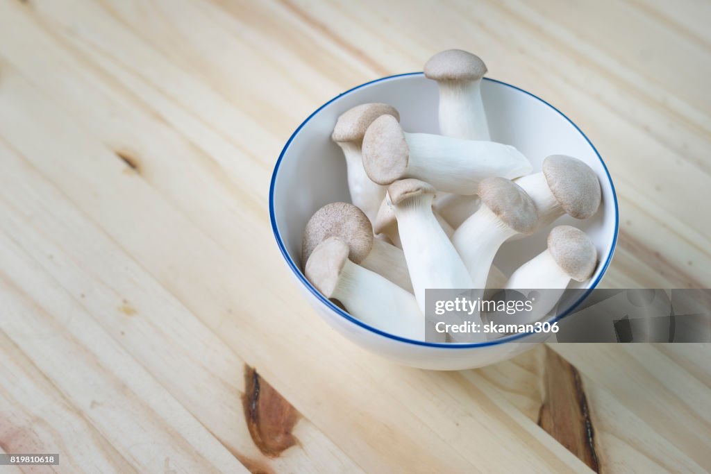 Clear light organic Japanese mushroom on wooden table