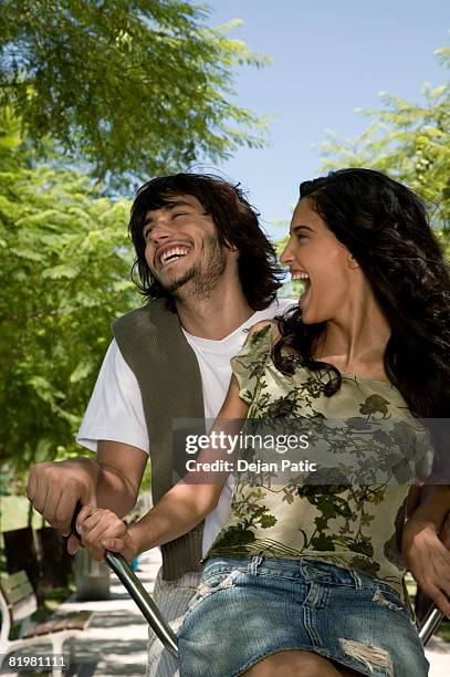 two friends riding a bicycle - short skirts on bicycles stock pictures, royalty-free photos & images