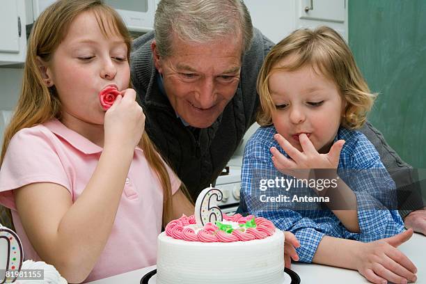 grandfather celebrating a birthday with his grandchildren - senior man grey long hair stock pictures, royalty-free photos & images