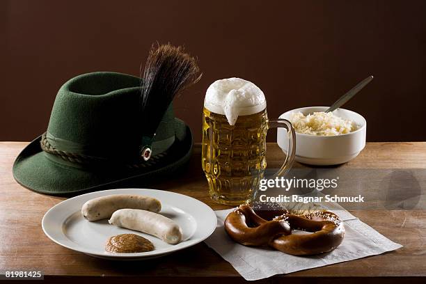 still life of stereotypical german food, beer and hat - duitse gerechten stockfoto's en -beelden