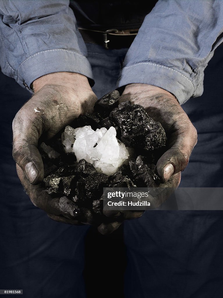 A miner holding quartz crystals in cupped hands