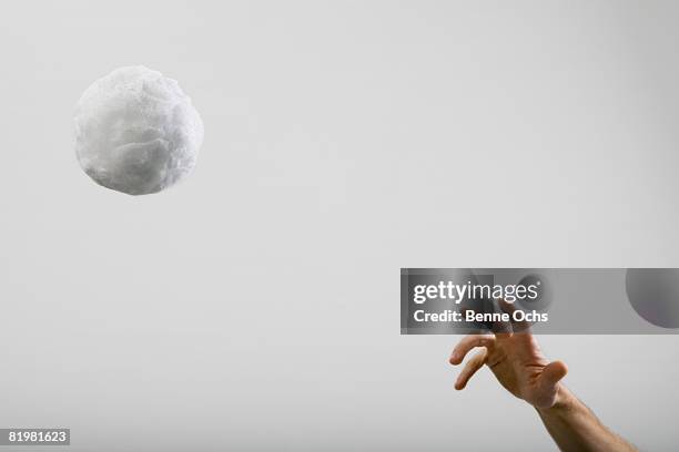 a human hand throwing a large cotton ball - gooien stockfoto's en -beelden