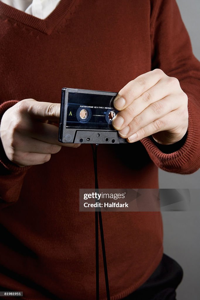 A man winding tape into a cassette