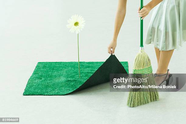 woman sweeping under artificial turf rug, waist down - 掃地 個照片及圖片檔