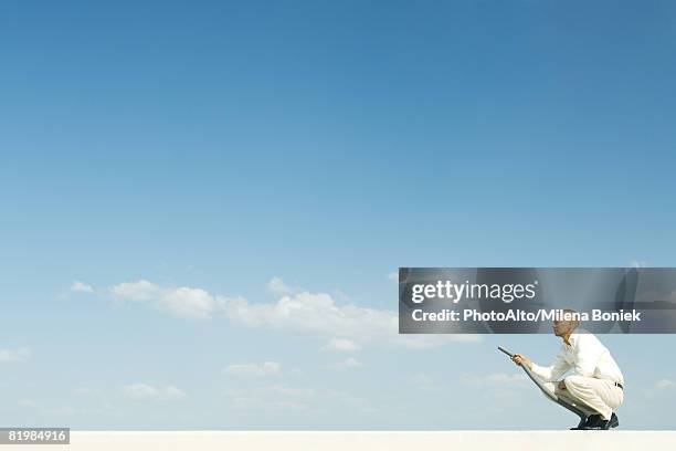 man vacuuming clouds, full length - forced perspective stock pictures, royalty-free photos & images