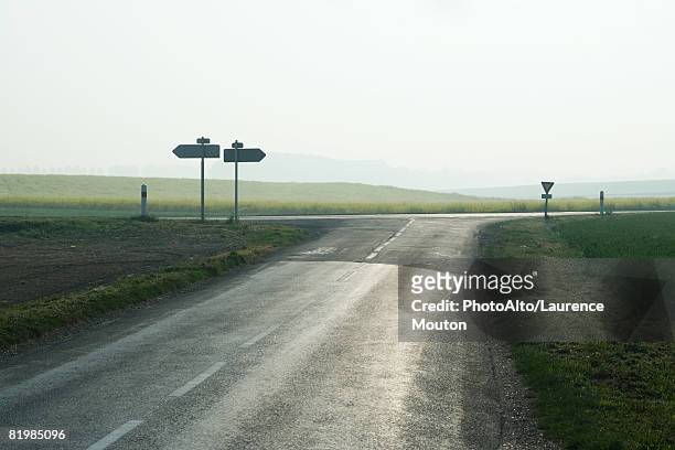 forked road in countryside - road intersection stock pictures, royalty-free photos & images