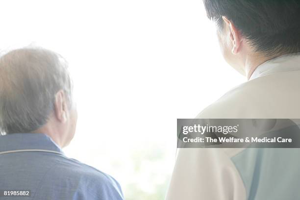 rear view of male nurse and mature man - man with gray hair stock pictures, royalty-free photos & images