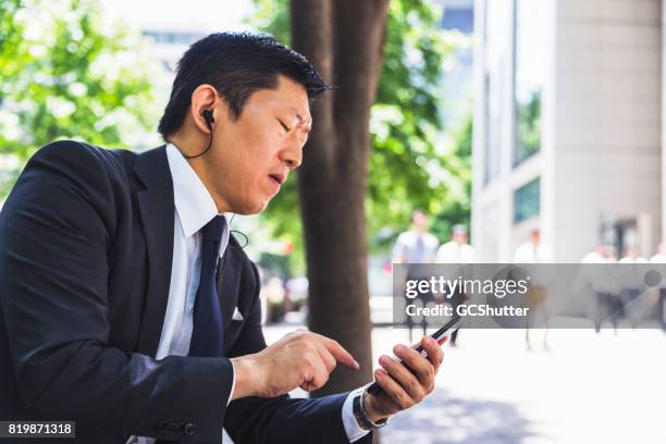 receiving a message on the way home from work - center for asian american media stock pictures, royalty-free photos & images