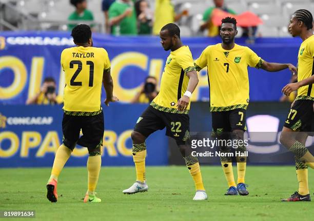 Romario Williams of Jamaica celebrates with teammates Jermaine Taylor and Shaun Francis after scoring a second half goal against Canada in a...