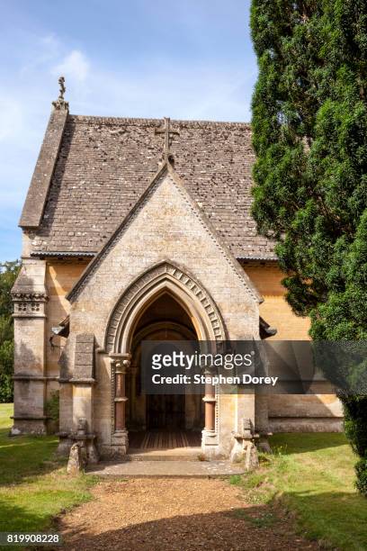 the porch of st peter's church in the cotswold village of daylesford, gloucestershire uk - the tomb of warren hastings (died 1818) is outside at the end of the chancel. - daylesford stockfoto's en -beelden