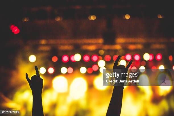 rock hands in air at concert - rock alternativo fotografías e imágenes de stock