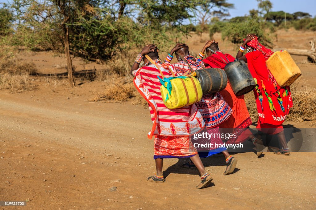 African women from Maasai tribe carrying water, Kenya, East Africa